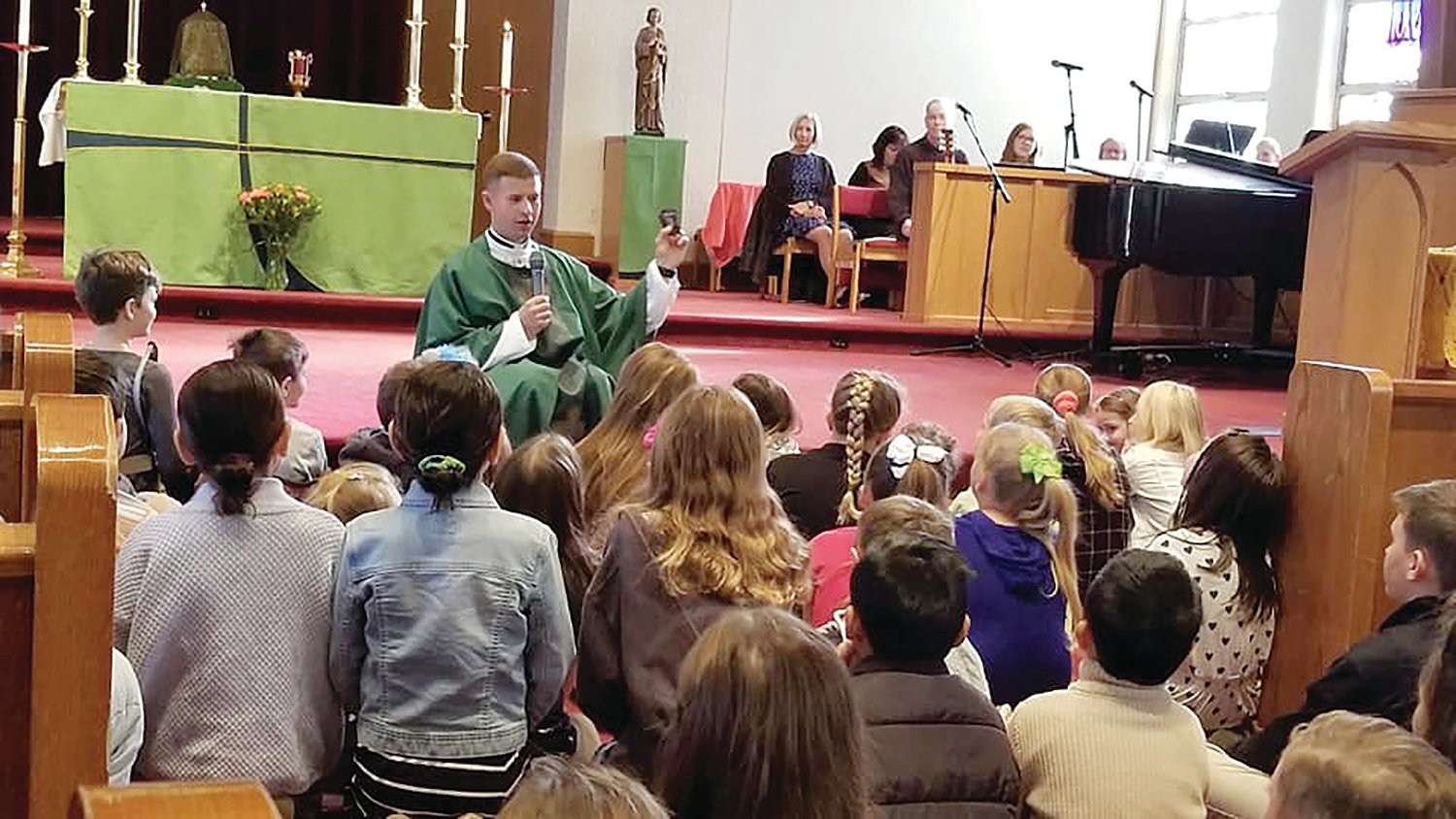 He speaks with young children as they prepare to receive the sacraments.